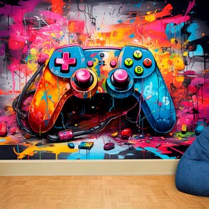 Könnte beinhalten: Ein lebendiges Wandbild mit einem großen, farbenfrohen Videospiel-Controller. Der Controller ist in Orange-, Blau- und Rosatönen bemalt und hat ein schwarzes Kabel. Der Hintergrund ist ein Spritzer leuchtender Farben, mit einem blauen Sitzsack in der Ecke.