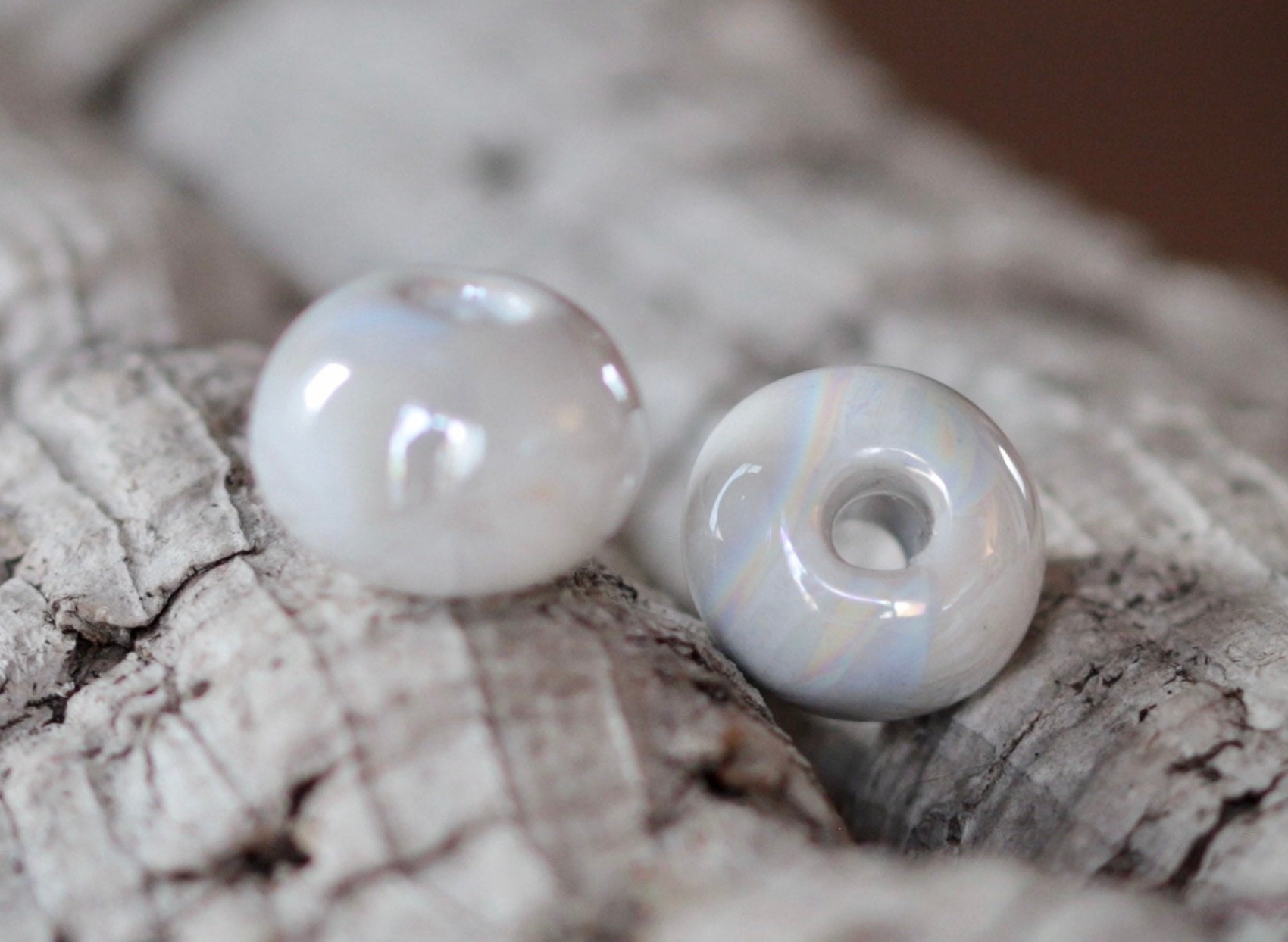 Grosse perle en céramique. Blanc irisé. Diamètre 20 mm.