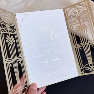 Luxurious wedding invitation made of gold foil, in a lace-cut cover in the Gatsby style