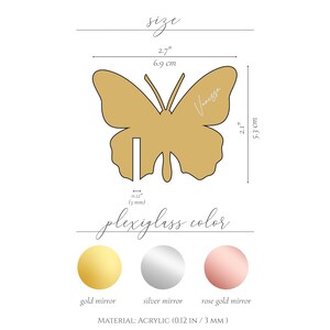 Może przedstawiać: Złota, lustrzana, akrylowa dekoracja w kształcie motyla, o szerokości 6,9 cm i wysokości 5,3 cm, z napisem "Vanessa". Obrazek przedstawia opcje kolorystyczne: złoto, srebro i r&oacute;żowe złoto.