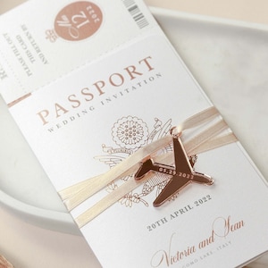 ÉCHANTILLON : faire-part de passeport en or rose, faire-part de mariage avec gravure d'une feuille d'or rose et d'un avion, carte d'embarquement, destination de mariage
