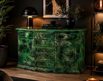 May include: A wooden sideboard featuring a vibrant green fern leaf pattern across its entire surface. The piece includes a central column of five stacked drawers with small round knobs, flanked by two side cabinets with doors, all finished in a glossy sheen.