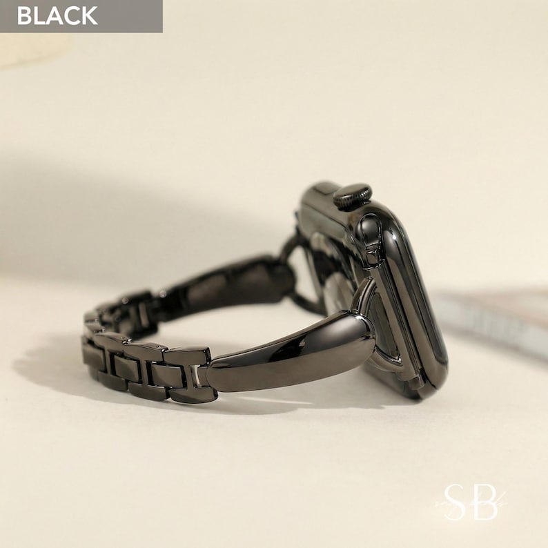May include: A black smartwatch with a matching black metal link band. The watch face is glossy and the band has a series of rectangular links. The word "BLACK" is in a gray box in the upper left corner.