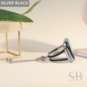 May include: A silver and black Apple Watch band with a chain detail. The band is made of metal and has a sleek, modern design.