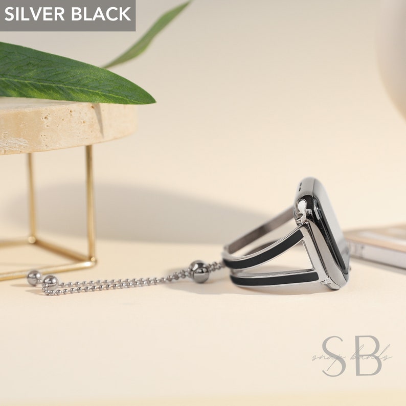 May include: A silver and black Apple Watch band with a chain detail. The band is made of metal and has a sleek, modern design.
