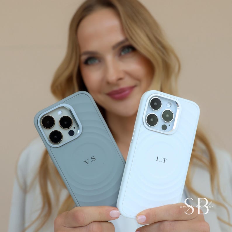 Puede incluir: Dos fundas de tel&eacute;fono, una azul claro y otra azul p&aacute;lido, se muestran. La funda azul claro tiene las iniciales "V.S" y la funda azul p&aacute;lido tiene las iniciales "L.T". Ambas fundas tienen un dise&ntilde;o circular.