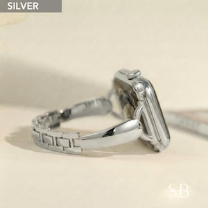 May include: A silver watch with a matching link band. The watch face is rectangular with rounded corners. The band is made of small, rectangular links. The word "SILVER" is in a gray box in the upper left corner.