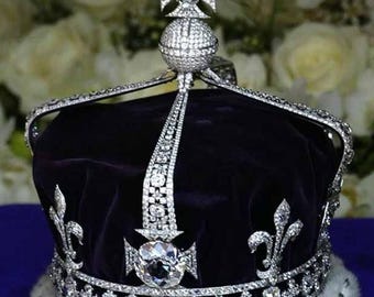 Może przedstawiać: Korona z czarną aksamitną czapką i dużym diamentem w środku. Korona jest ozdobiona mniejszymi diamentami i ma białe futerko.