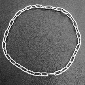 May include: A silver chain necklace with a simple oval link design.