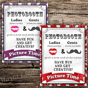 May include: Two photo booth signs with red and white stripes and purple and white stripes. The signs have the text "PHOTOBOOTH" in black letters. The signs also have the text "Ladies" and "Gents" with instructions for each. The signs also have the text "Have Fun and Get Creative!" and "Picture Time!"