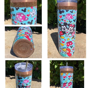 May include: A brown and gold glitter tumbler with a blue and white Mickey Mouse and Minnie Mouse design. The tumbler has a clear lid and a straw.