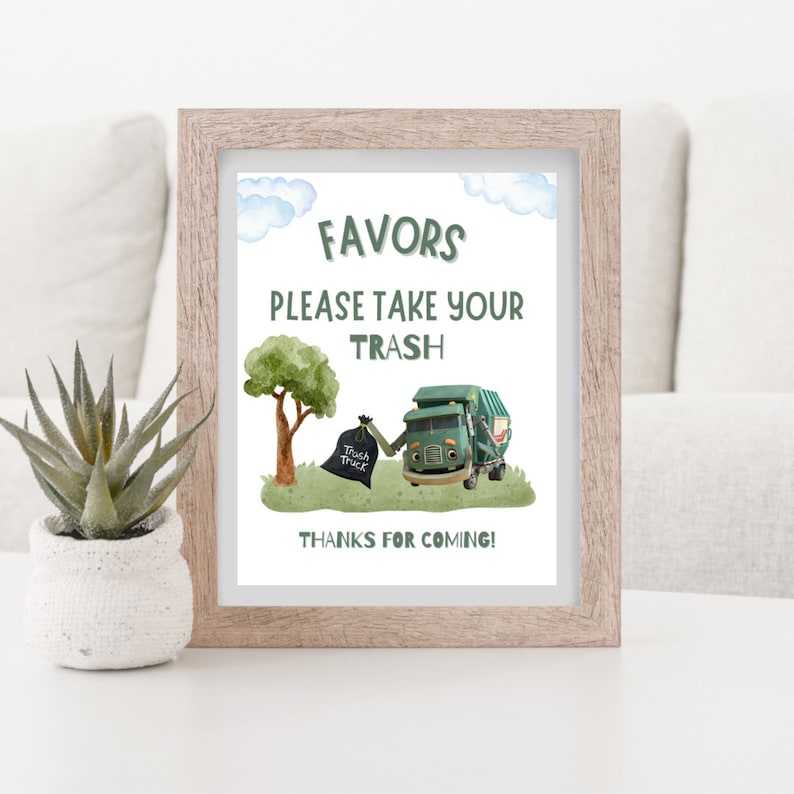 K&ouml;nnte beinhalten: Ein gerahmter Druck mit den Worten &bdquo;FAVORS PLEASE TAKE YOUR TRASH THANKS FOR COMING!&ldquo; zeigt einen Cartoon-M&uuml;llwagen, einen Baum und einen M&uuml;llsack. Der Druck befindet sich in einem hellbraunen Rahmen, mit einer kleinen Sukkulentenpflanze in einem wei&szlig;en Topf links.