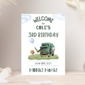 K&ouml;nnte beinhalten: Ein Willkommenszeichen f&uuml;r eine 3. Geburtstagsparty mit einem gr&uuml;nen M&uuml;llwagen und einem Jungen, der einen blauen Ballon h&auml;lt. Das Schild sagt "Welcome to Cole's 3rd Birthday" und "Honk! Honk!" mit dem Datum "June 15th, 2024" dazwischen.