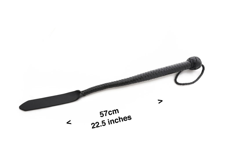 May include: Black leather riding crop with a braided handle and a flat paddle. The crop is 22.5 inches long.