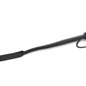 May include: A black leather paddle with a braided handle and a loop at the end.