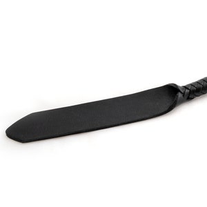 May include: A black leather whip with a braided handle.
