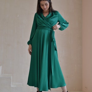 May include: A long-sleeved emerald green wrap dress with a V-neckline and a tie at the waist.