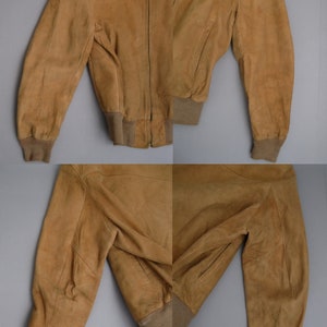K&ouml;nnte beinhalten: Eine braune Wildlederbomberjacke mit Rei&szlig;verschluss und gerippten Strickb&uuml;ndchen und Bund.