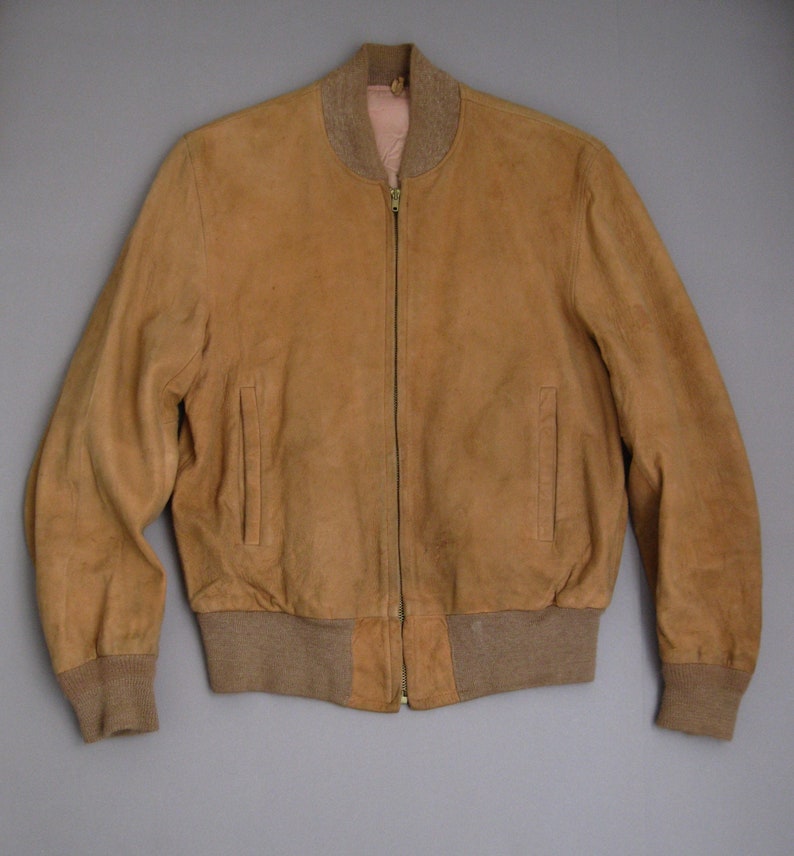 K&ouml;nnte beinhalten: Eine braune Wildlederbomberjacke mit Rei&szlig;verschluss und gerippten Strickb&uuml;ndchen und Bund.