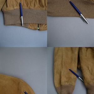 K&ouml;nnte beinhalten: Eine braune Wildlederbomberjacke mit Rei&szlig;verschluss und gerippten Strickb&uuml;ndchen und Bund.