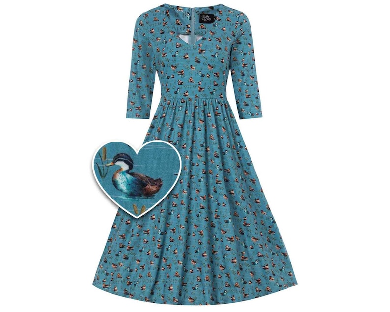 Puede incluir: Un vestido azul turquesa con estampado de patos. El vestido tiene cuello en V y mangas 3/4. El estampado de patos es de estilo acuarela y presenta un pato nadando en un estanque con juncos.
