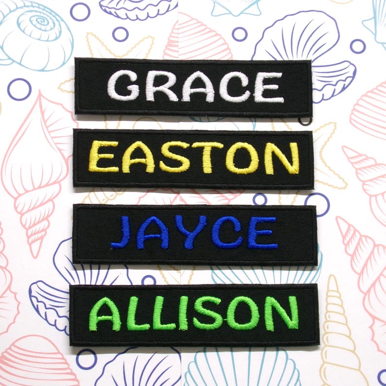 May include: Four black fabric name tags with white, yellow, blue, and green embroidered lettering. The names are "GRACE", "EASTON", "JAYCE", and "ALLISON".