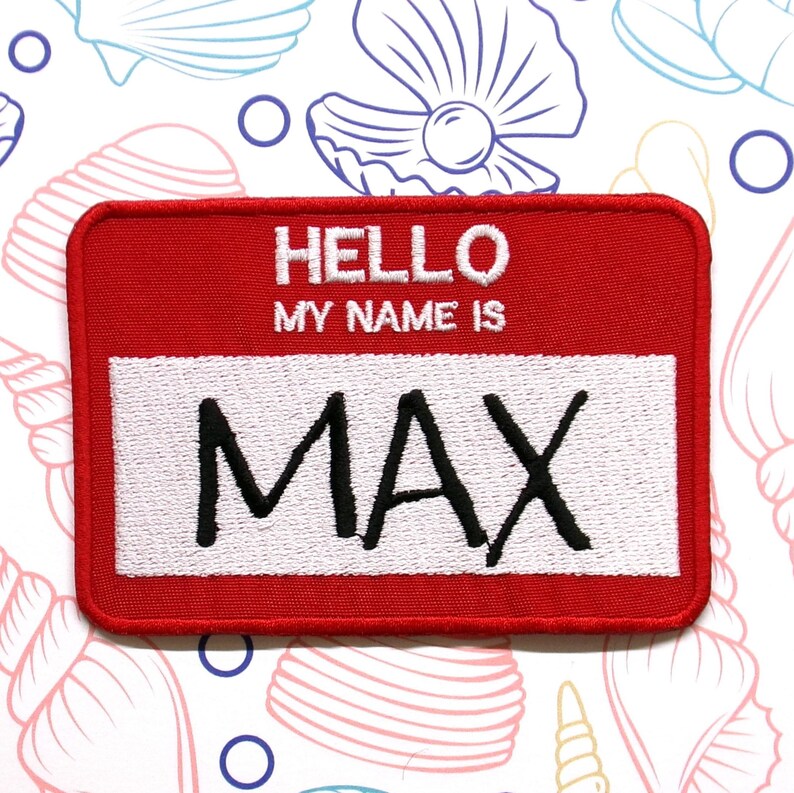 May include: Red felt name tag with white border and white text that reads "HELLO MY NAME IS MAX".