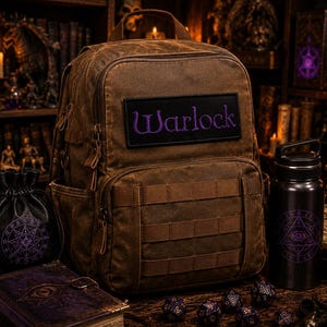 K&ouml;nnte beinhalten: Ein brauner Rucksack aus Segeltuch mit einem schwarzen rechteckigen Aufn&auml;her, auf dem das Wort Warlock in violettem Garn gestickt ist. Der Rucksack verf&uuml;gt &uuml;ber einen Tragegriff, mehrere Rei&szlig;verschlussf&auml;cher und horizontale Riemen.