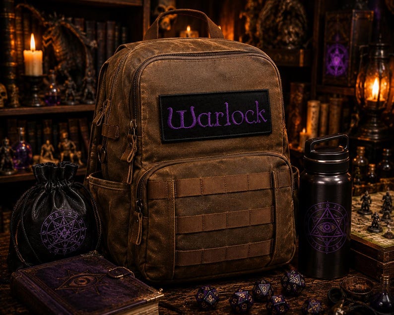 K&ouml;nnte beinhalten: Ein brauner Rucksack aus Segeltuch mit einem schwarzen rechteckigen Aufn&auml;her, auf dem das Wort Warlock in violettem Garn gestickt ist. Der Rucksack verf&uuml;gt &uuml;ber einen Tragegriff, mehrere Rei&szlig;verschlussf&auml;cher und horizontale Riemen.