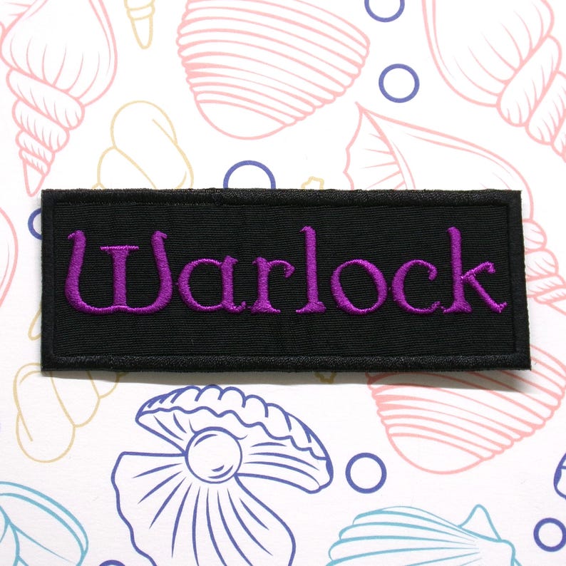 K&ouml;nnte beinhalten: Ein rechteckiger, schwarz bestickter Aufn&auml;her mit dem Wort Warlock, das in leuchtend violettem Garn gestickt ist. Der Aufn&auml;her hat einen sauberen, festen Rand und ist vor einem hellen Hintergrund mit verschiedenen Muschelmotiven platziert.