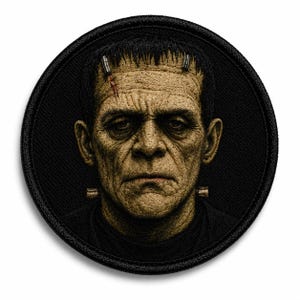May include: A circular embroidered patch featuring a detailed portrait of Frankenstein's monster. The figure has textured, tan-colored skin, dark hair, a stitched forehead scar, and metallic neck bolts, all set against a solid black background.