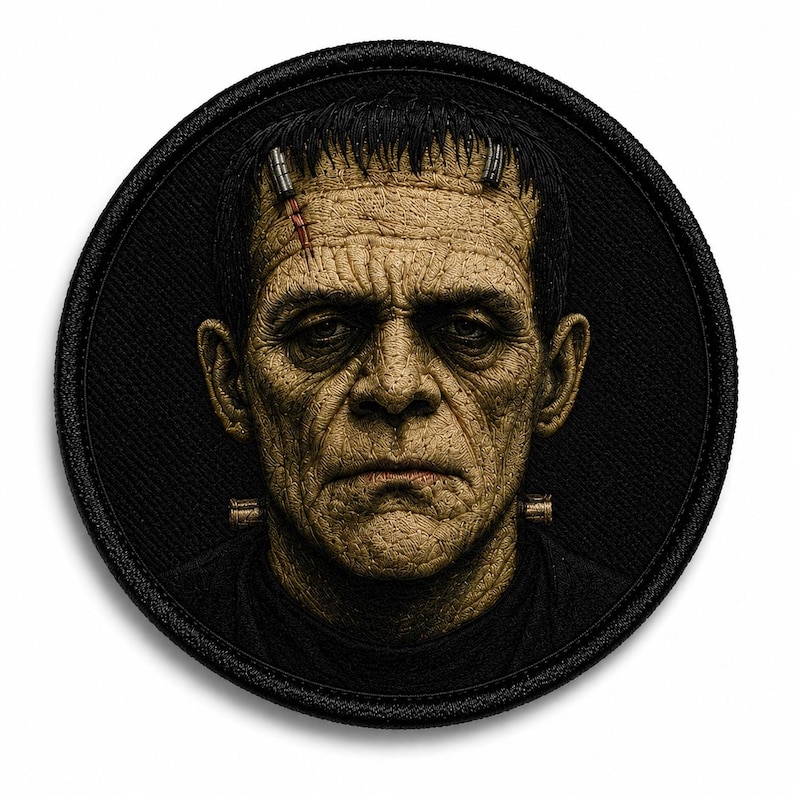 May include: A circular embroidered patch featuring a detailed portrait of Frankenstein's monster. The figure has textured, tan-colored skin, dark hair, a stitched forehead scar, and metallic neck bolts, all set against a solid black background.