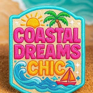 K&ouml;nnte beinhalten: Gestickter Aufn&auml;her mit K&uuml;stenmotiv. Der Aufn&auml;her zeigt die Worte "COASTAL DREAMS CHIC" in Pink und Orange, zusammen mit einer Sonne, einer Palme, Wellen und einem Segelboot. Der Aufn&auml;her hat einen t&uuml;rkisfarbenen Rand und einen sandigen Hintergrund.