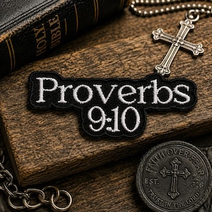 May include: A black embroidered patch with the text "Proverbs 9:10" in white. A silver cross pendant hangs on a chain. A leather-bound Bible and a circular coin with a cross are also visible.
