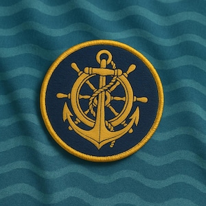 Può includere: Una toppa ricamata blu navy e oro con un design nautico. La toppa circolare presenta un bordo dorato e un disegno di timone, ancora e corda dorati su sfondo blu navy. Lo sfondo è verde acqua.