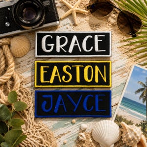 Puede incluir: Tres parches rectangulares bordados con fondos de tela negra. El parche superior presenta el texto blanco GRACE, el parche central tiene el texto amarillo EASTON con un borde amarillo, y el parche inferior muestra el texto azul JAYCE.
