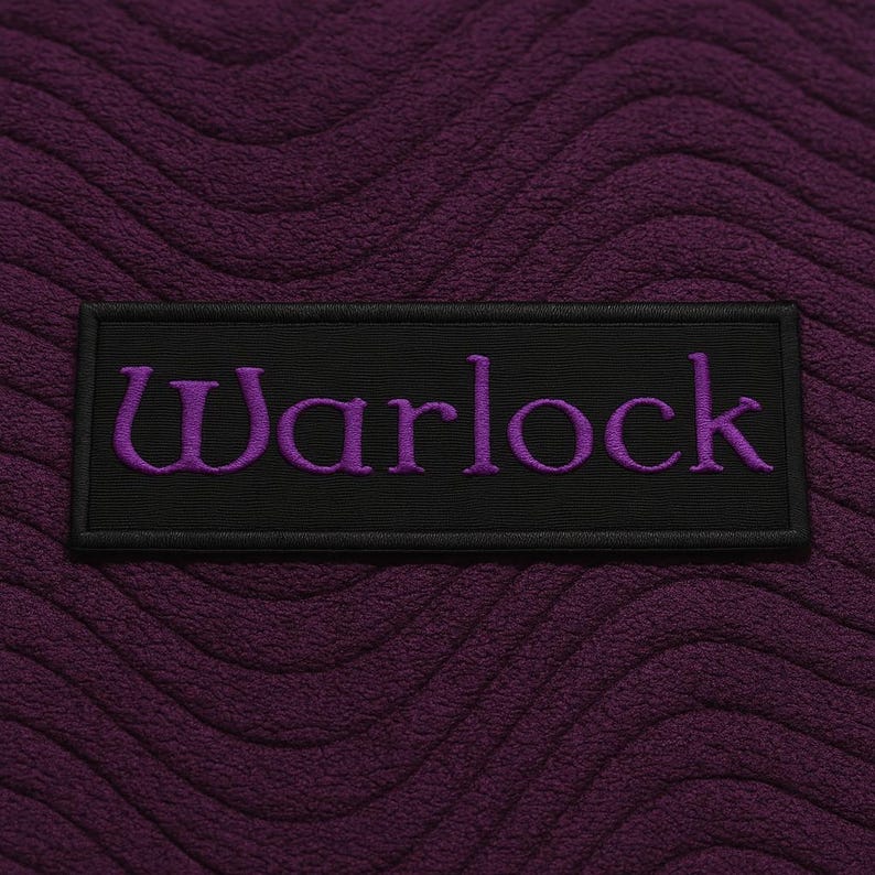 K&ouml;nnte beinhalten: Ein rechteckiger schwarzer Aufn&auml;her mit dem Wort Warlock, das in violettem Garn gestickt ist. Der Aufn&auml;her ist auf einem tiefvioletten Stoffhintergrund zentriert, der eine texturierte, wellenf&ouml;rmige und erhabene Struktur aufweist.