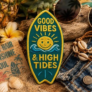 Puede incluir: Un parche turquesa en forma de tabla de surf con ribete amarillo y las palabras "GOOD VIBES & HIGH TIDES" en amarillo. El parche presenta un sol sonriente y olas del océano. Otros elementos incluyen gafas de sol, conchas marinas y una piña.