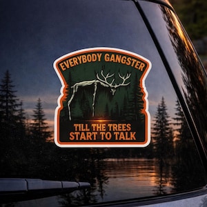 Op de afbeelding: Een rechthoekige sticker met een boslandschap en de tekst "EVERYBODY GANGSTER" boven "TILL THE TREES START TO TALK". De sticker toont een hert met groot gewei, bomen en een meer.