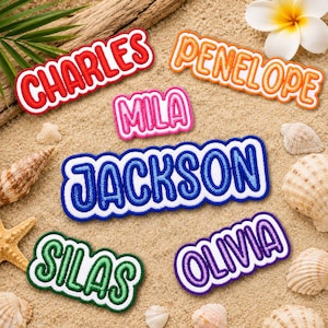 May include: Embroidered name patches in various colors, including red, orange, pink, blue, green, and purple. Names include Charles, Penelope, Mila, Jackson, Silas, and Olivia. Patches are displayed on a sandy surface with seashells and tropical foliage.
