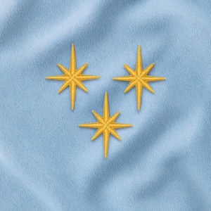 May include: Close-up of a light blue fabric with three embroidered gold stars. The stars are arranged in a triangular pattern, each with eight points. The fabric has a subtle texture.