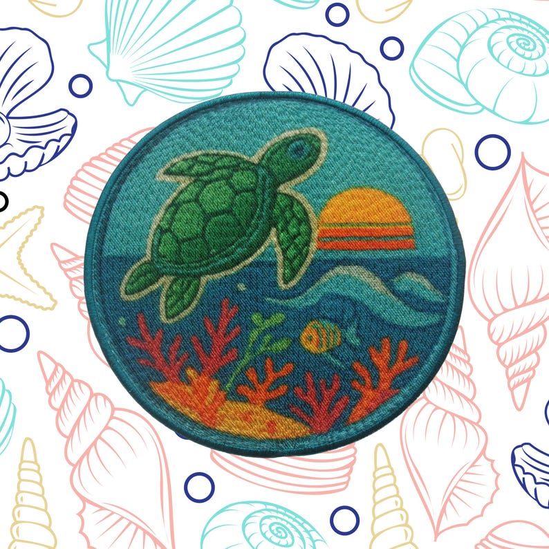 K&ouml;nnte beinhalten: Ein runder, gestickter Aufn&auml;her mit einer gr&uuml;nen Meeresschildkr&ouml;te, die &uuml;ber einem blauen Ozean mit untergehender Sonne schwimmt. Korallen und ein Fisch sind unter Wasser sichtbar. Der Hintergrund ist wei&szlig; mit Muschelbildern.