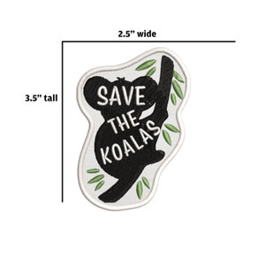 May include: A white embroidered patch with a black koala silhouette holding onto a branch. The koala is surrounded by green leaves and the text "SAVE THE KOALAS" is written in white on the patch. The patch is 3.5 inches tall and 2.5 inches wide.
