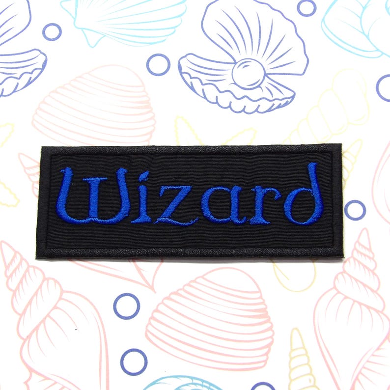 Peut inclure: &Eacute;cusson brod&eacute; noir avec le mot "Wizard" en lettres bleues.