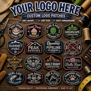 May include: A collection of sixteen custom embroidered logo patches in various shapes and designs, featuring text and graphics for businesses like coffee shops, construction, and grooming, arranged on a dark wooden surface with sewing tools.