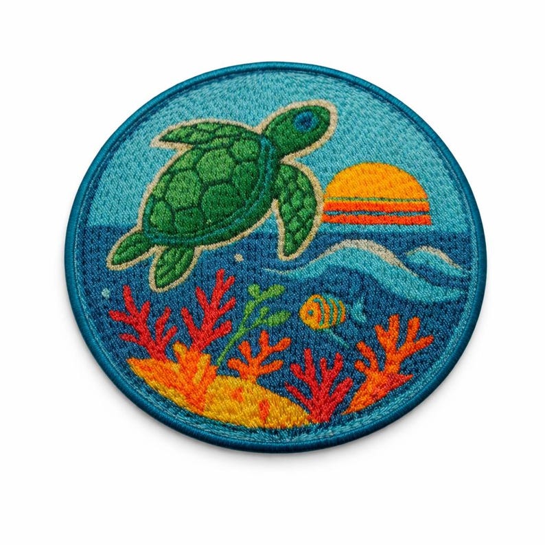 May include: Round embroidered patch featuring a green sea turtle swimming above coral and a setting sun. The patch has a blue border and depicts an underwater scene with a fish and sea plants.