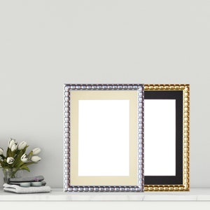 Op de afbeelding: Twee fotolijsten met sierlijke parelranden. De lijst aan de linkerkant is zilverkleurig met een crèmekleurige passe-partout en de lijst aan de rechterkant is goudkleurig met een zwarte passe-partout.