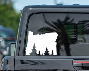 May include: White vinyl decal of the state of Oregon with a silhouette of a forest of pine trees at the bottom.