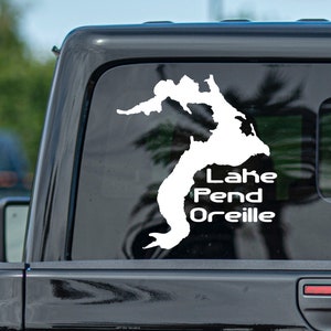May include: White vinyl decal of the outline of Lake Pend Oreille, Idaho, on a black car window.