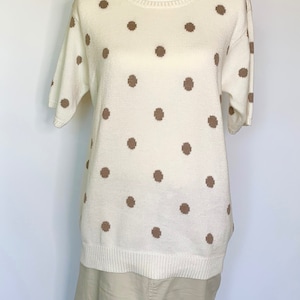 May include: A white short-sleeved sweater with brown polka dots.